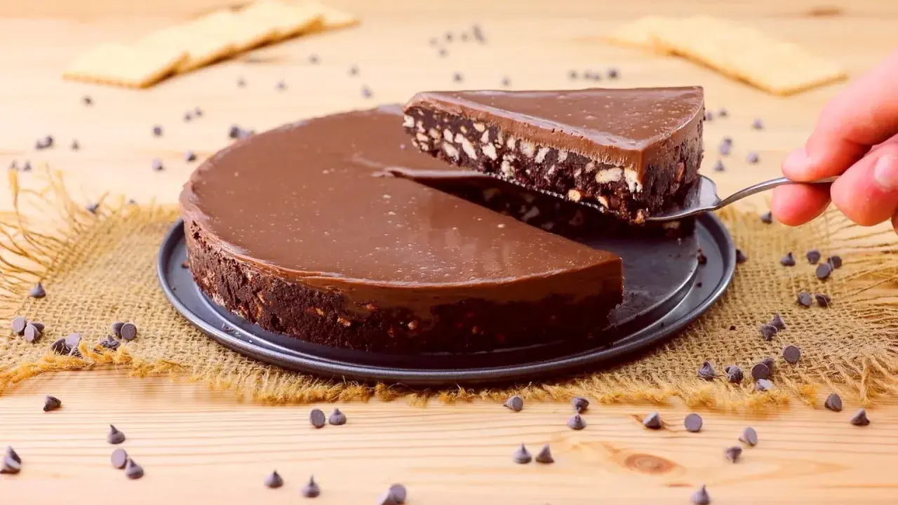 Una fetta di torta fredda con biscotti e cioccolato viene sollevata da una tortiera.