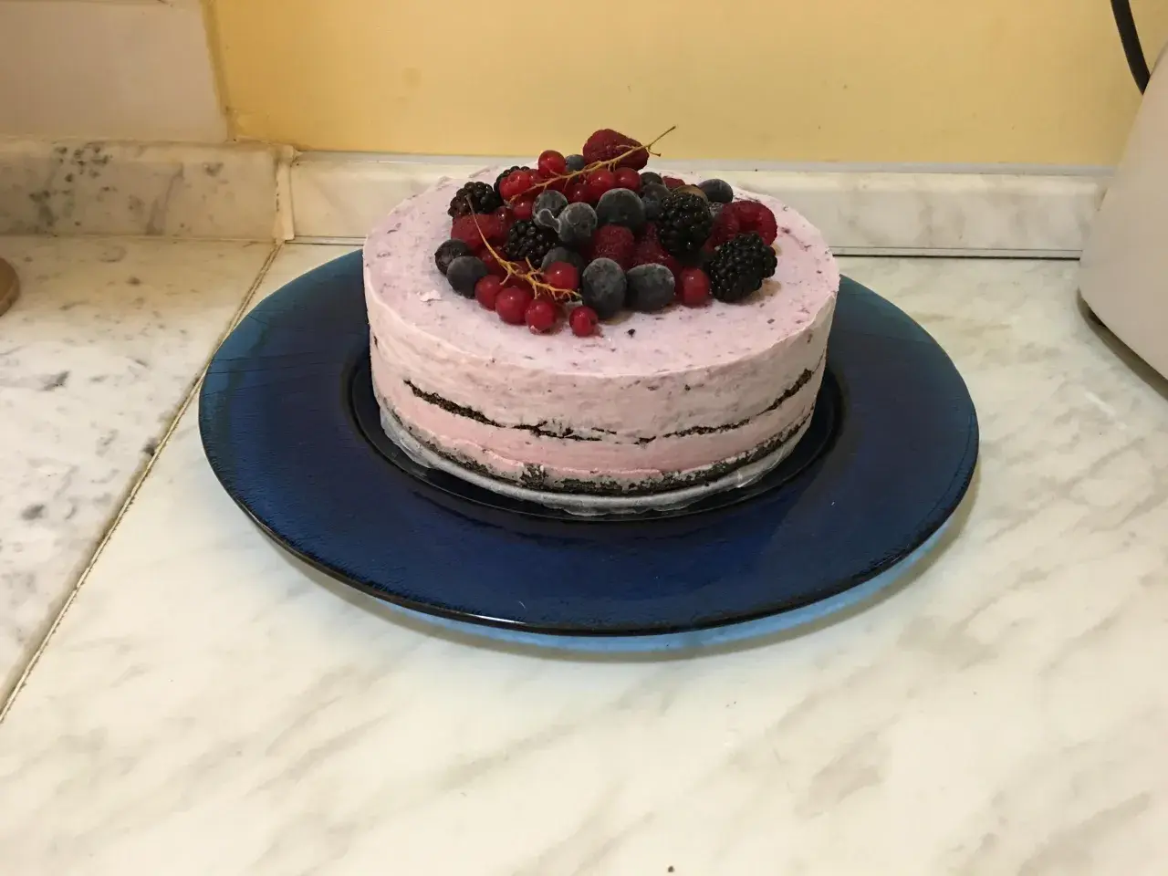Torta gelato con base di biscotti secchi, guarnita con frutti di bosco freschi e congelati.