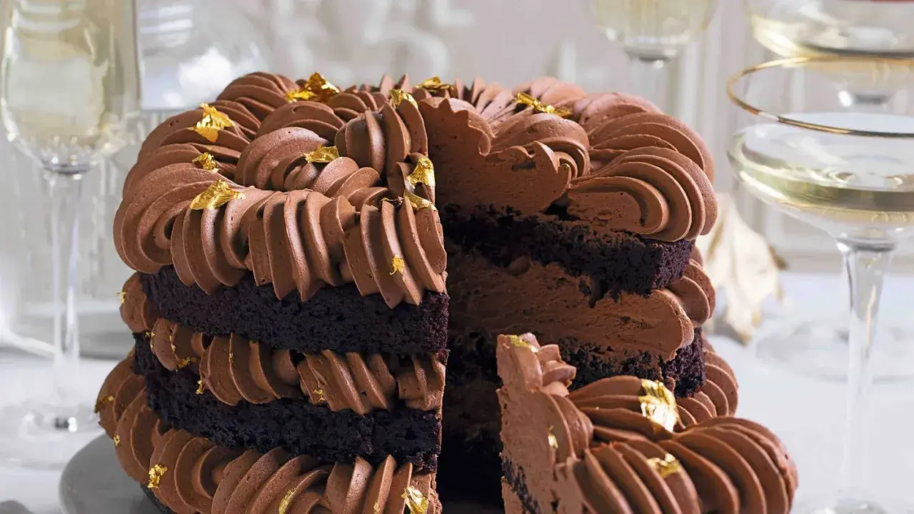 Torta a strati con pan di spagna al cacao, ricoperta da una golosa crema al cioccolato e decorata con foglia d'oro.