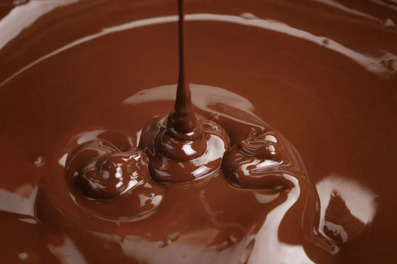 Cioccolato fuso che cola, un'immagine perfetta per spiegare come sciogliere il cioccolato nel microonde.