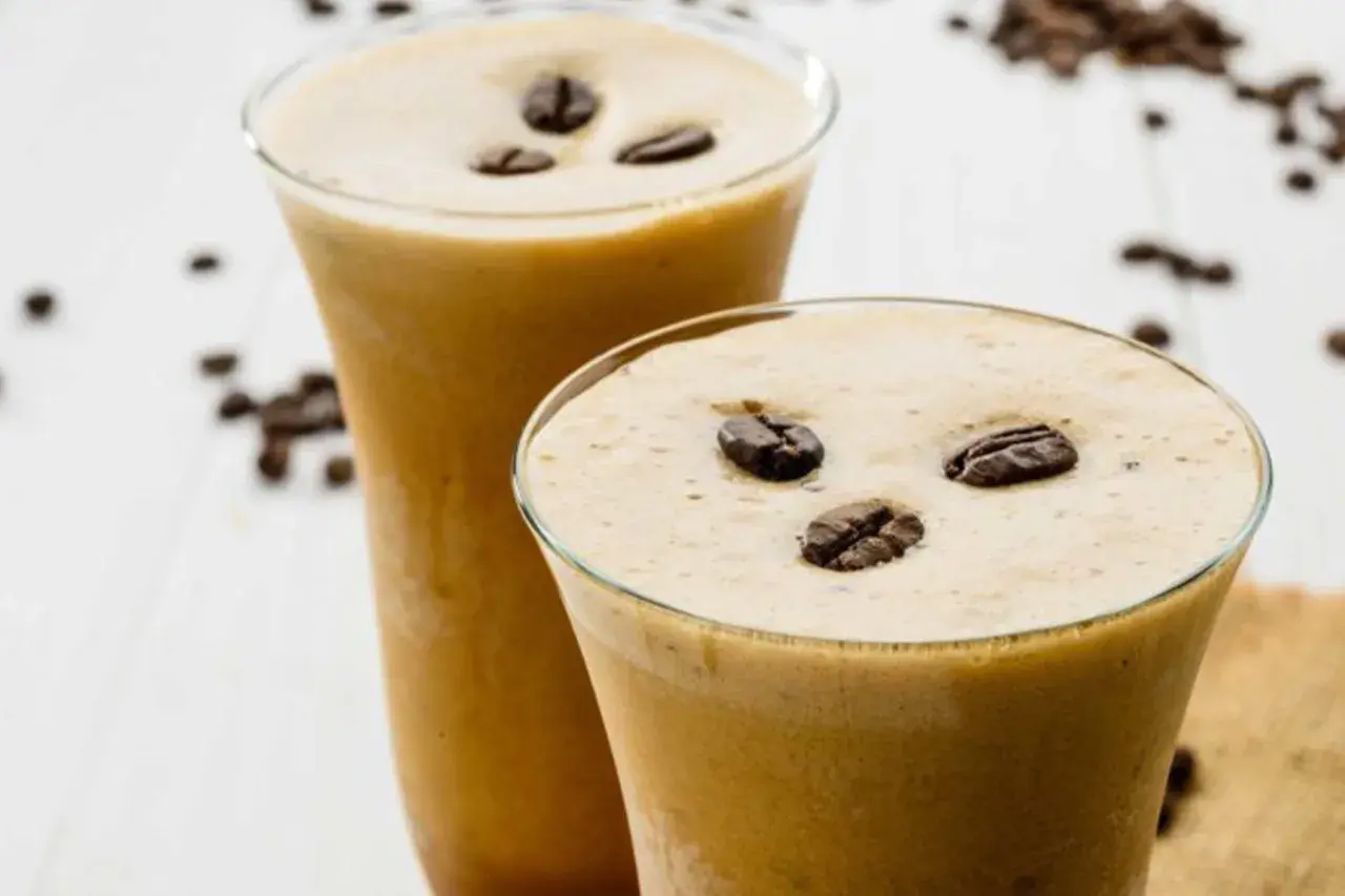 Due bicchieri di cremoso sorbetto al caffè, guarniti con chicchi tostati, invitano a una pausa rinfrescante.