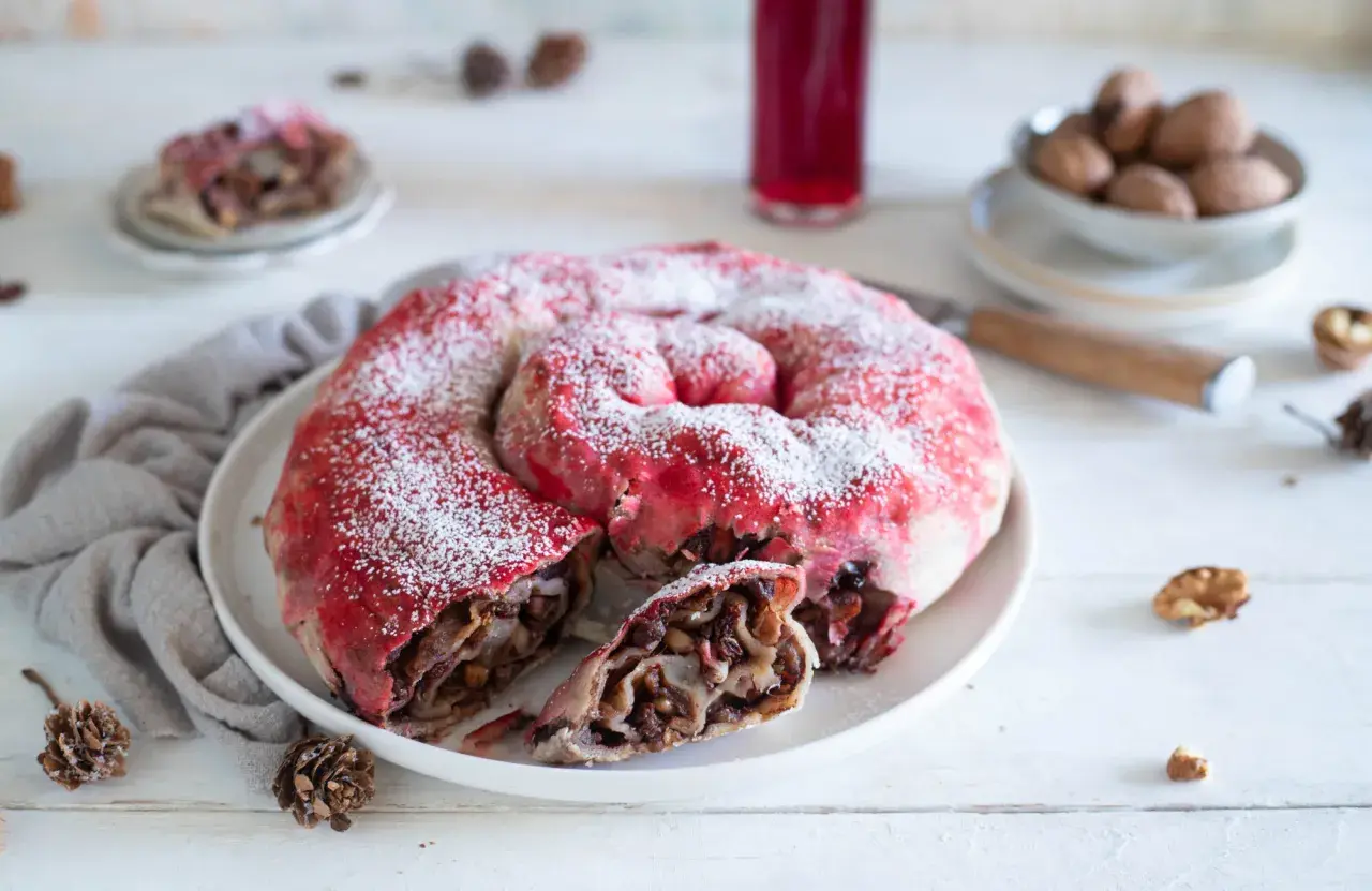 Dolce a spirale con ripieno di frutta e noci, spolverato di zucchero a velo, ricorda una rocciata umbra.