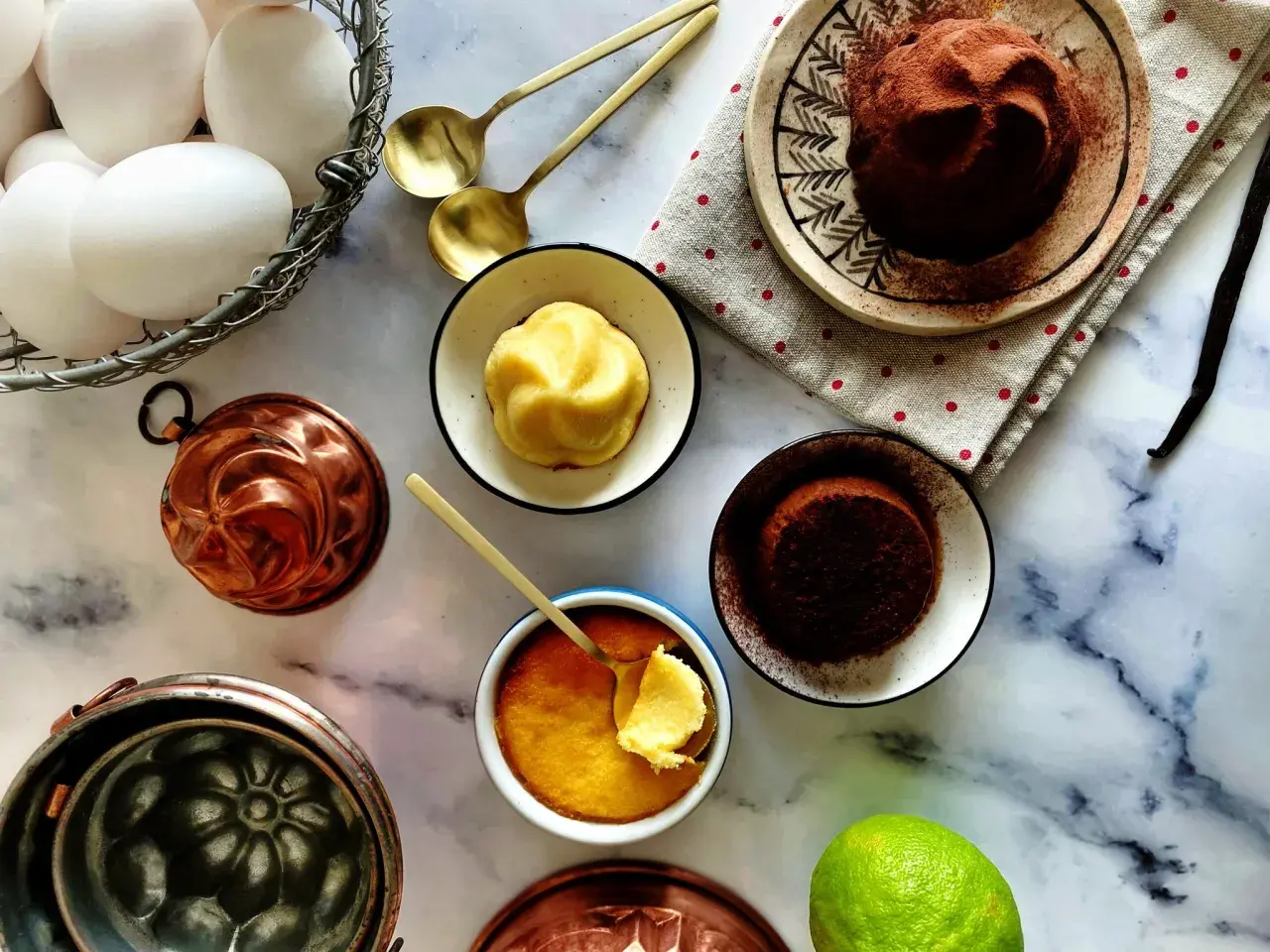 Un delizioso budino fatto in casa, pronto per essere gustato. Uova fresche, stampi in rame e una spolverata di cacao completano la scena.
