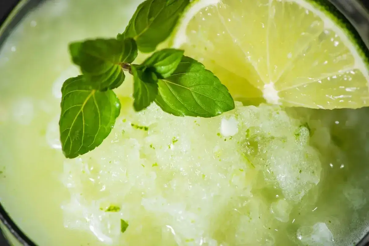 Granita alla menta fatta in casa, rinfrescante e profumata, guarnita con menta fresca e una fetta di lime.