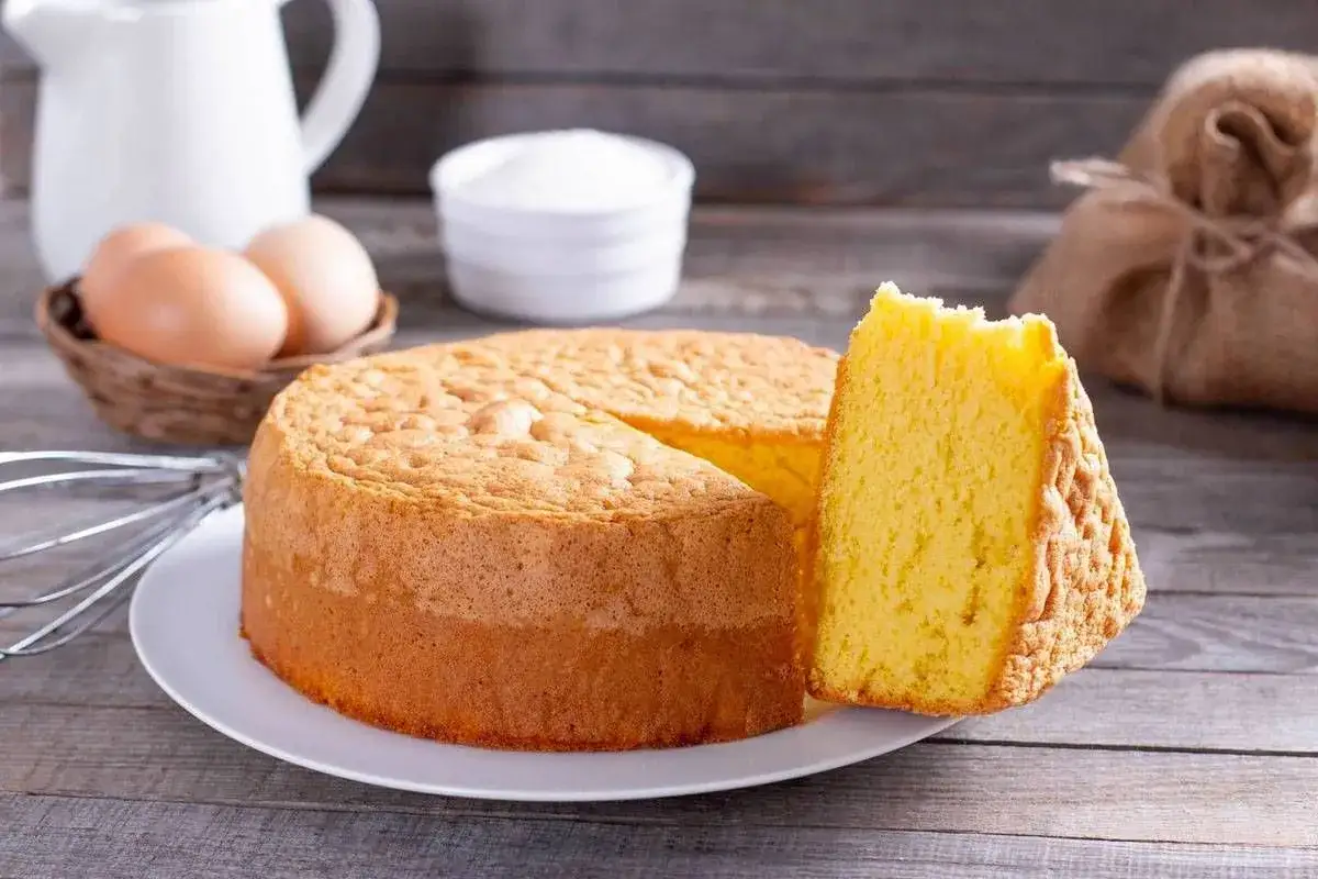 Pan di Spagna soffice e dorato, pronto per essere bagnato con sciroppo o liquore. Ingredienti base per dolci deliziosi.