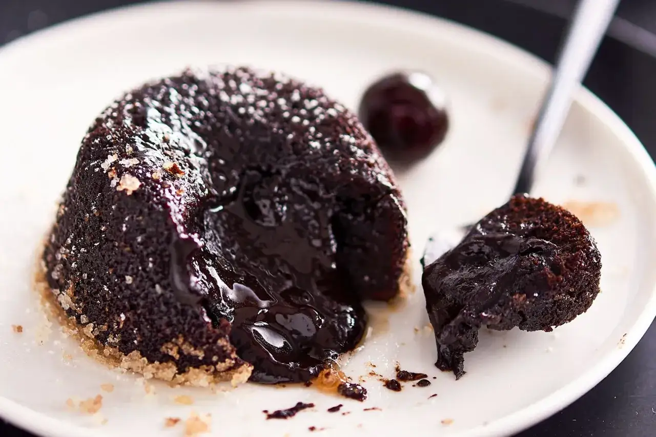 Cupcake al cioccolato con cuore fuso e una ciliegia. La dolcezza che cola.