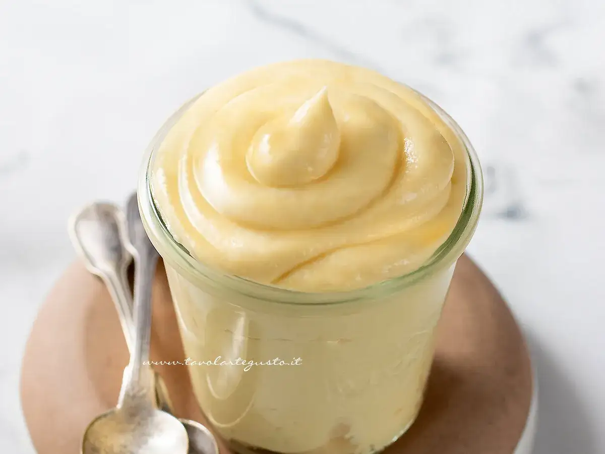 Deliziosa crema chiboust in un vasetto, pronta per essere gustata con due cucchiaini d'argento.