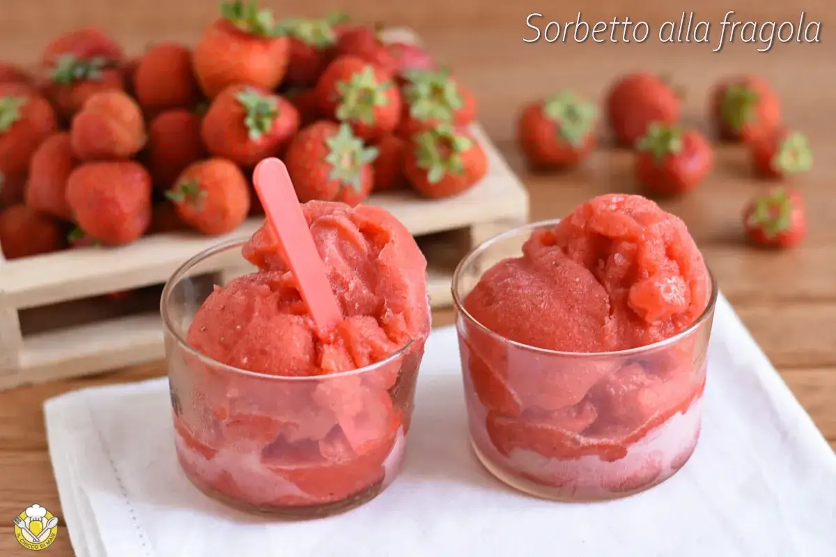 Due bicchieri di sorbetto cremoso alle fragole, con fragole fresche sullo sfondo.