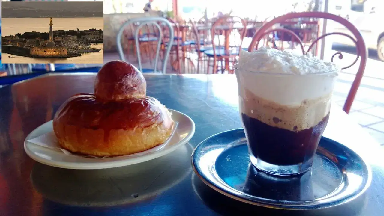 Brioche e granita al caffè, un classico siciliano, con vista sul mare e monumento.