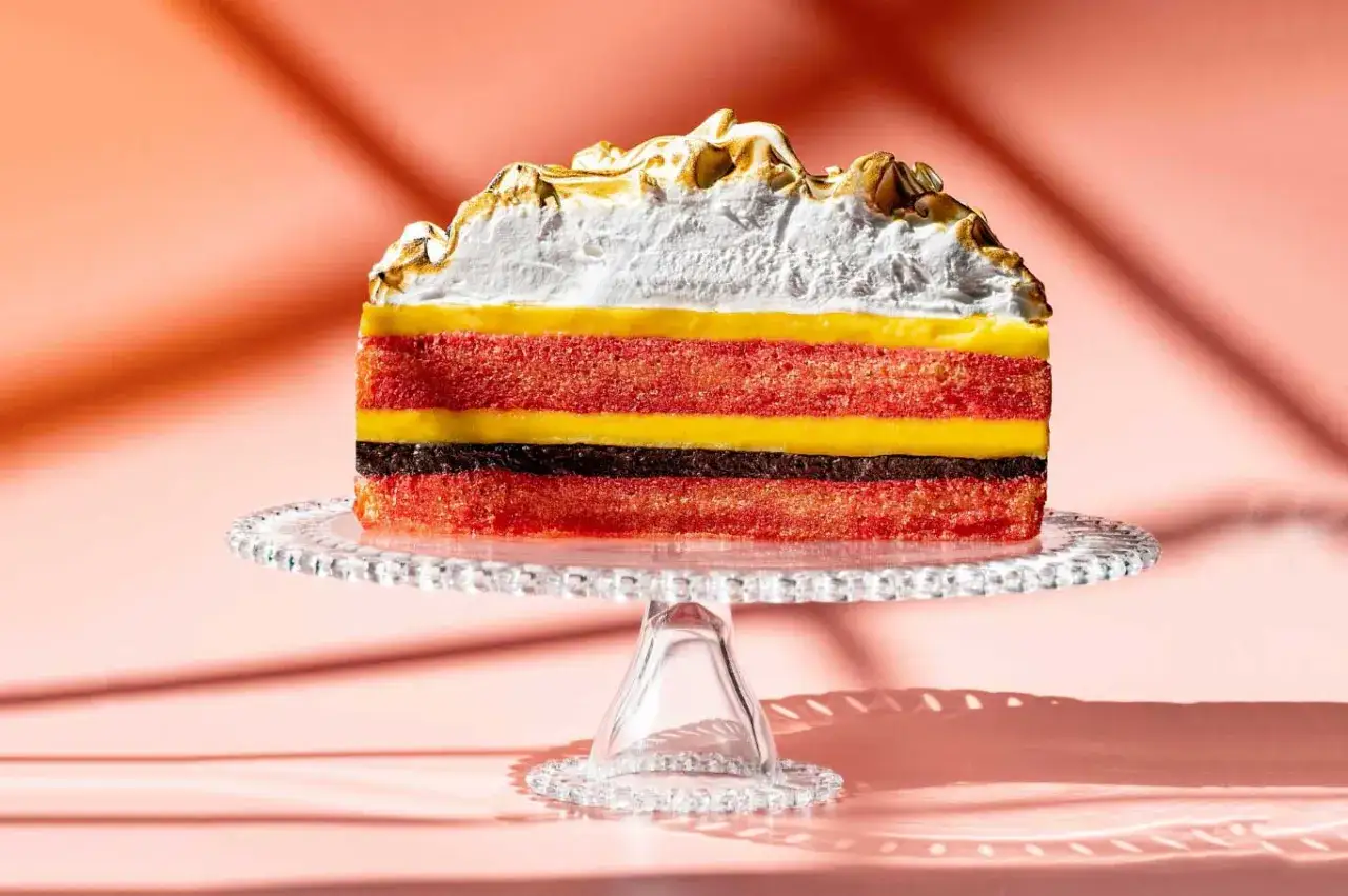 Fetta di torta multistrato con pan di Spagna rosso, crema gialla e cioccolato, coronata da meringa abbrustolita. Ideale come crema zuppa inglese per farcire torte.