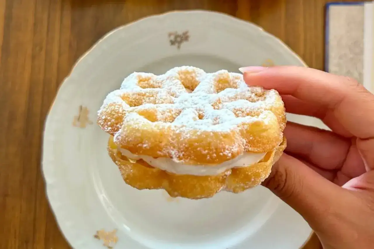 Un delizioso bacio pantesco, un dolce ripieno di crema, cosparso di zucchero a velo, pronto per essere gustato.