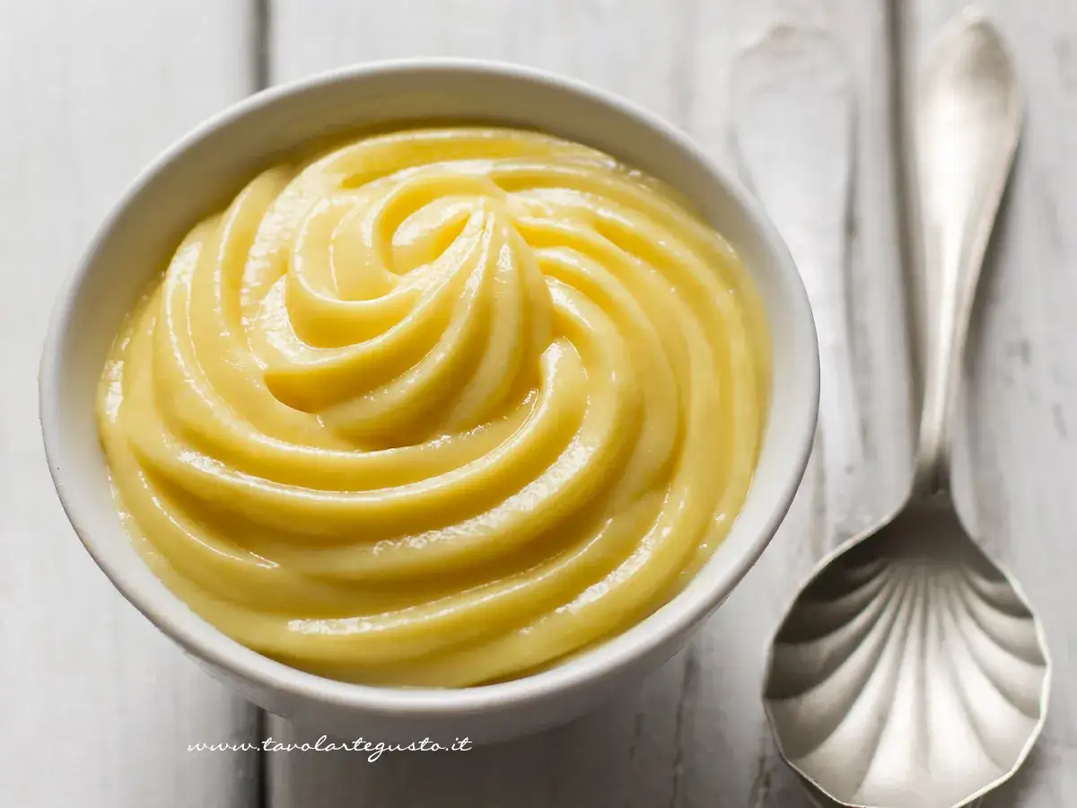 Una ciotola di deliziosa crema pasticcera senza uova, liscia e vellutata, pronta per essere gustata.