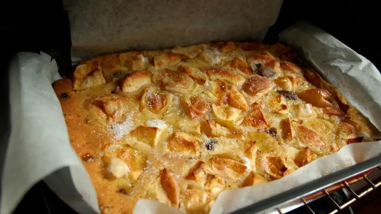 Ciambella romagnola appena sfornata, dorata e profumata, con mele e zucchero.