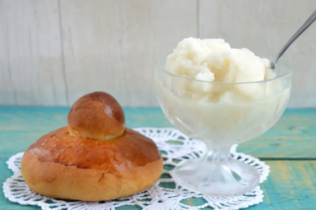Brioche con granita siciliana, un classico estivo preparato con gelatiera, servito in una coppa di cristallo.