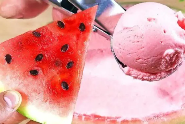 Una fetta di cocomero succoso accanto a una pallina di gelato al cocomero rosa, pronta per essere gustata.