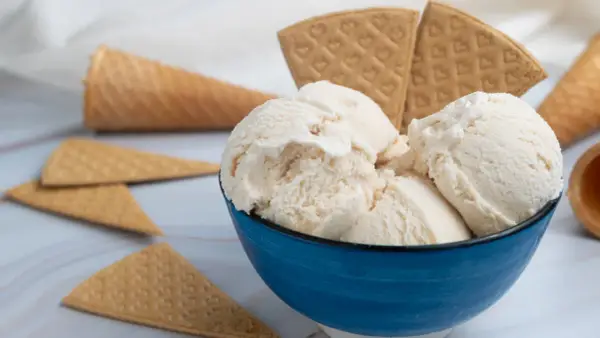 Coppetta blu con gelato fiordilatte cremoso, circondata da coni e cialde. Gli ingredienti base per un piacere semplice.